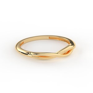 May include: A gold-colored ring with a twisted design. The ring is simple and elegant.