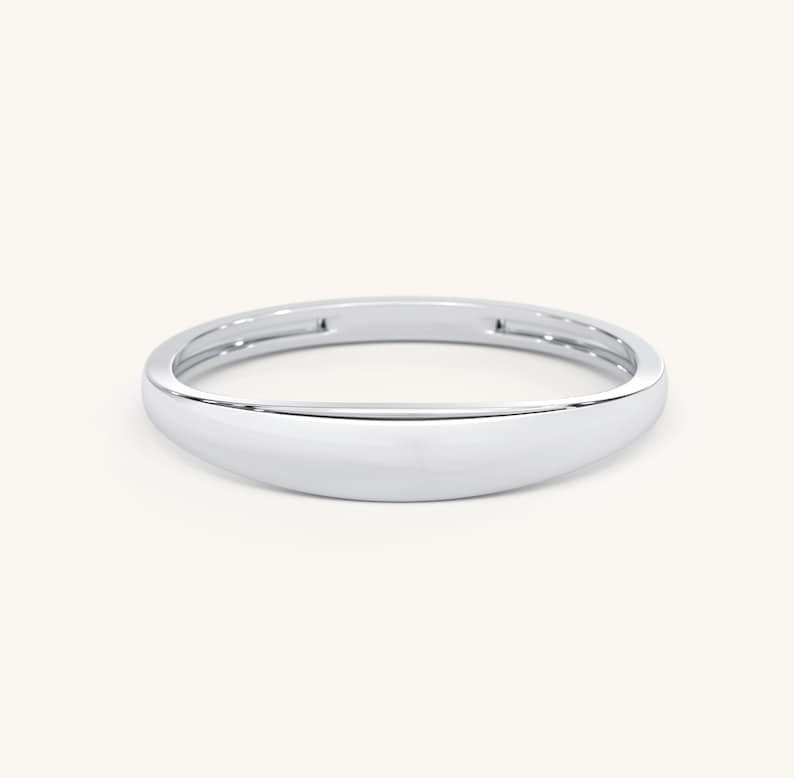 May include: A simple, silver band ring with a rounded, slightly domed top.