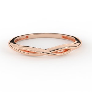 May include: A rose gold ring with a twisted design. The ring is simple and elegant.