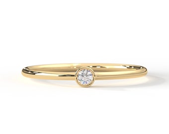 May include: A simple gold band ring with a single, small, round diamond.