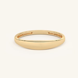 May include: A simple gold band ring with a rounded, slightly curved top.