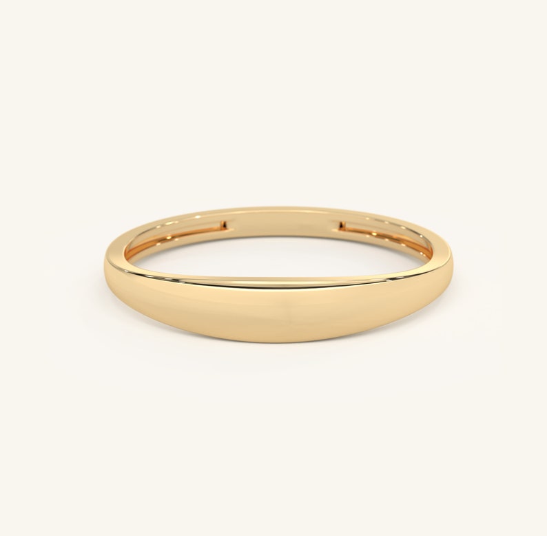 May include: A simple gold band ring with a rounded, slightly curved top.