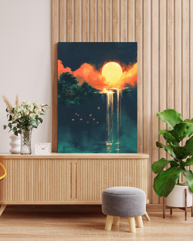 May include: A painting of a sunset over a waterfall with a large, bright yellow sun in the sky. The painting is framed and hanging on a wall in a room with a wooden floor and a wooden cabinet.