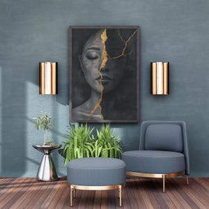 K&ouml;nnte beinhalten: Ein blauer Sessel mit goldenen Beinen und einem passenden Hocker. Ein gerahmtes Bild einer Frau mit goldenen Rissen auf einem dunklen Hintergrund h&auml;ngt an der Wand. Zwei goldene Wandleuchten befinden sich auf beiden Seiten des Bildes.