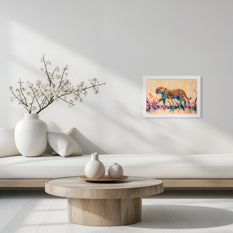 May include: A framed artwork featuring a cheetah in a colorful, abstract style. The cheetah is depicted with orange spots and is set against a backdrop of tall, colorful grass. The artwork is displayed in a white frame.