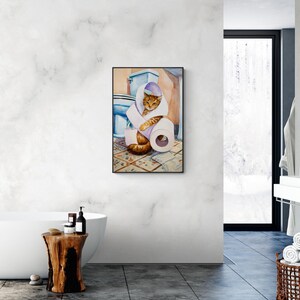 Peut inclure: Peinture &agrave; l'aquarelle d'un chat tigr&eacute; orange et marron envelopp&eacute; dans du papier toilette dans une salle de bain. Un rouleau de papier toilette blanc et des toilettes bleues sont &eacute;galement visibles. L'&oelig;uvre est encadr&eacute;e.