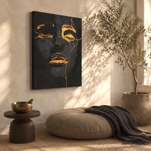 May include: A rectangular wall art canvas featuring a dark, abstract portrait of a face with closed eyes and lips highlighted in metallic gold. The image incorporates gold-coloured cracks across the facial features, creating a high-contrast design.