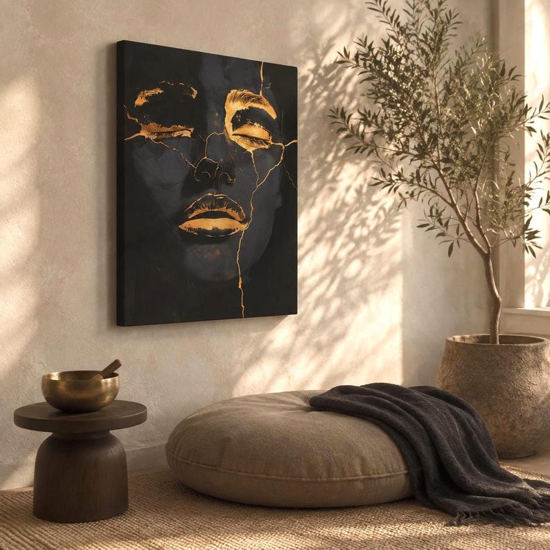 May include: A rectangular wall art canvas featuring a dark, abstract portrait of a face with closed eyes and lips highlighted in metallic gold. The image incorporates gold-coloured cracks across the facial features, creating a high-contrast design.