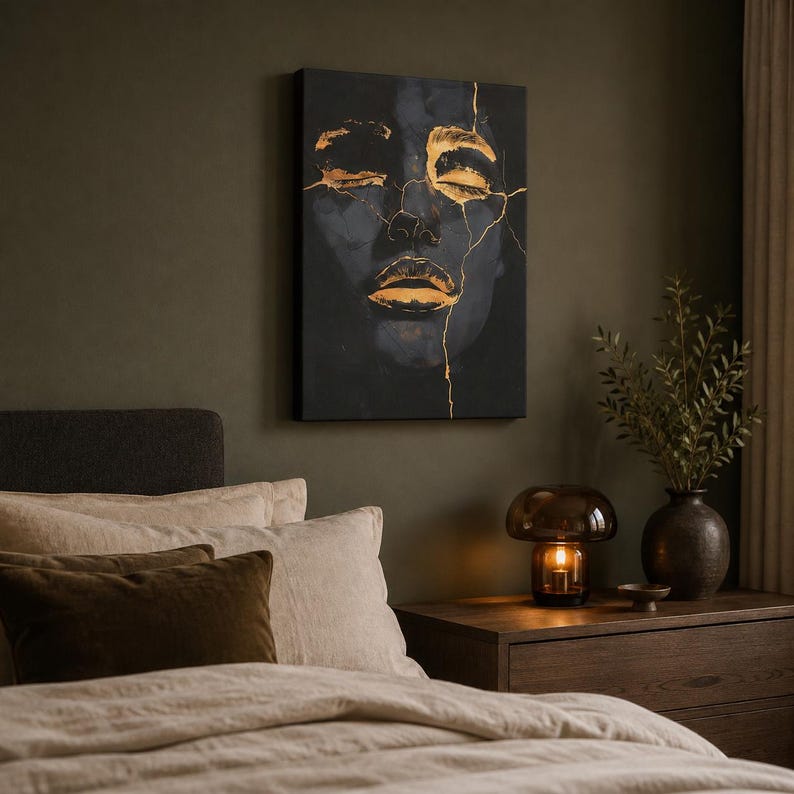 May include: A rectangular canvas wall art piece featuring a dark, moody portrait of a face with closed eyes and lips highlighted in metallic gold paint. The image includes thin, branching gold lines that resemble cracks across the facial features.