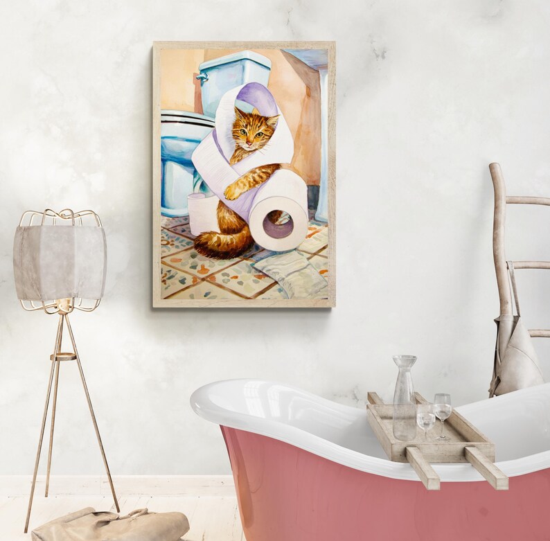 Peut inclure: Une impression encadr&eacute;e &agrave; l'aquarelle repr&eacute;sente un chat roux envelopp&eacute; dans du papier toilette dans une salle de bain. Le chat est au centre, entour&eacute; de toilettes, de papier toilette et d'un sol carrel&eacute; &agrave; motifs. L'&oelig;uvre est dans un cadre en bois clair.