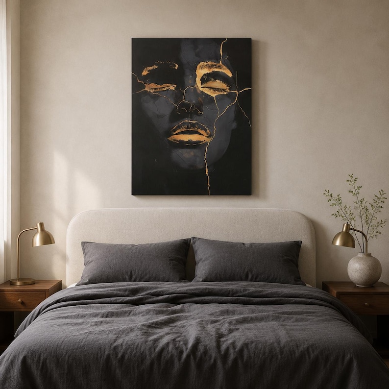 May include: A rectangular wall art canvas featuring a dark, shadowy portrait of a face with closed eyes and lips highlighted in metallic gold. Thin, jagged gold lines resembling cracks run across the forehead, eyes, and nose of the dark figure.