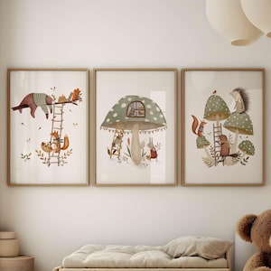May include: Three framed woodland-themed art prints. The prints feature illustrations of animals, including a bear, fox, and hedgehog, with mushrooms and ladders. The prints are displayed above a small wooden daybed and a brown teddy bear.