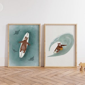 Puede incluir: Dos ilustraciones enmarcadas de un oso marrón surfeando en una tabla de surf blanca. La primera ilustración muestra al oso acostado en la tabla de surf con tres rayas nadando a su alrededor. La segunda ilustración muestra al oso montando una ola en la tabla de surf.