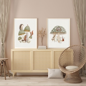 May include: Two framed illustrations of mushrooms with animal characters. The first illustration features a hedgehog, a squirrel, and a bird on a mushroom with a ladder. The second illustration features a bunny and a bird on a mushroom with a window.