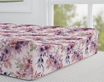 May include: A pink and purple floral fitted cot sheet with a watercolour design.