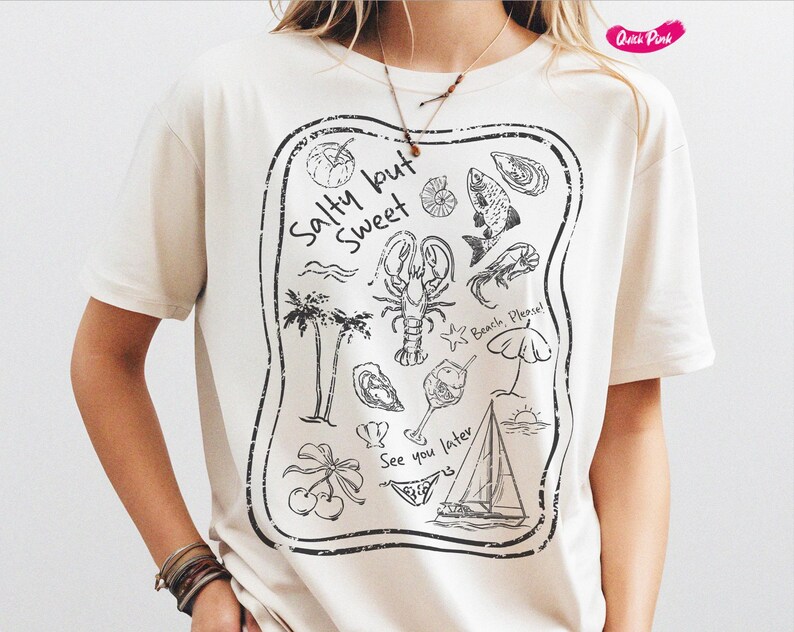 May include: White t-shirt with a black graphic print of a beach scene. The graphic includes a lobster, palm trees, a sailboat, a seashell, a fish, and the text "Salty but Sweet".