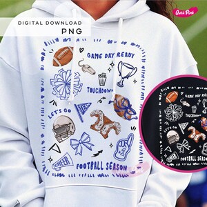 Peut inclure: Sweat à capuche blanc avec un motif sur le thème du football. Le motif comprend un ballon de football, un casque, des pompons et les mots "Game Day Ready" et "Football Season". Une version noire plus petite du motif est également visible.