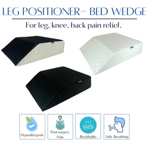 May include: Two black and white leg positioner bed wedges. The wedges are made of a soft, breathable material and are designed to help relieve leg, knee, and back pain. The wedges are hypoallergenic and can be used for post-surgery recovery. The text "LEG POSITIONER - BED WEDGE" and "For leg, knee, back pain relief." is displayed above the wedges.  Four icons are displayed below the wedges: a water drop with a checkmark, a person wearing a surgical mask, a wavy line with arrows pointing up, and a person with a mouth open.