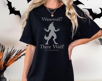 May include: Black t-shirt featuring a gray werewolf graphic with the text "Werewolf? There Wolf!" from Young Frankenstein. The design includes a howling werewolf silhouette. A Halloween-themed tee.