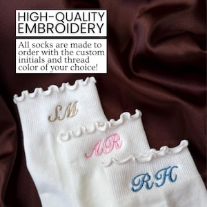 Personalized white ruffle socks with embroidered initials photographed on silky satin background featuring aesthetic custom pilates socks designed for women who love barre classes yoga outfits and trendy minimalist accessories with elegant pastel thread embroidery and feminine boutique inspired details making these socks perfect for bridesmaid gifts bridal party favors birthday presents college girl gifts self care baskets holiday gifts and cozy lounge wear fashion accessories
