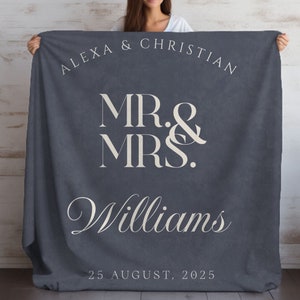 May include: A navy blue fleece blanket with the text "Alexa & Christian Mr. & Mrs. Williams 25 August, 2025" in white.