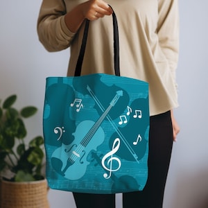 May include: A teal blue tote bag with a white violin and musical notes design. The bag has black handles.