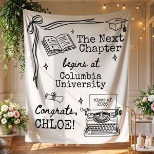 May include: A white graduation banner with black illustrations and text. The banner reads "The Next Chapter begins at Columbia University" and "Congrats, CHLOE!" with "class of 2026" displayed. The banner includes a graduation cap, book, and scroll.