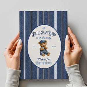 May include: A rectangular card with a dark blue and white vertical striped pattern. The center features an oval with the text A BLUE JEAN BABY is on the way!, EST. 2026, and Wishes for BABY WILLIAMS, surrounding a teddy bear in denim overalls.