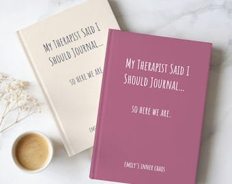 May include: Two hardcover journals, one cream and one mauve, each featuring the printed text "My Therapist Said I Should Journal... So Here We Are." The mauve journal also includes the text "Emily's Inner Chaos" at the bottom.