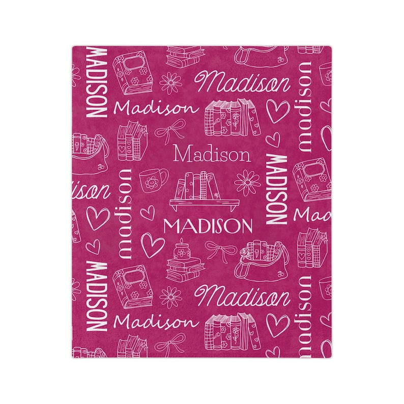 May include: A pink fabric with a white repeating pattern of books, hearts, flowers, and the name "Madison".