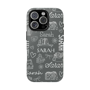 May include: A gray phone case with a white pattern of books, flowers, hearts, bows, and the name "Sarah" repeated throughout. The case has a glossy finish and a camera cutout.