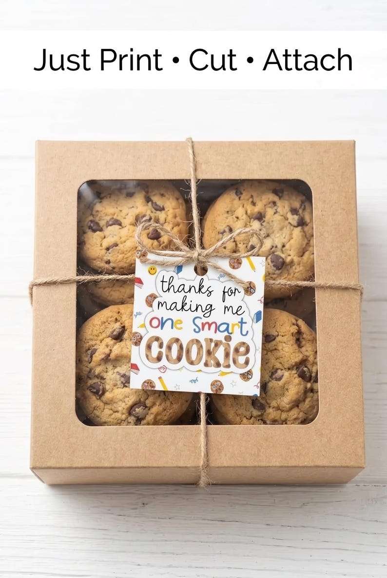 May include: A kraft paper box with a clear window, tied with twine, containing chocolate chip cookies. A tag reads "thanks for making me one smart cookie". The text "Just Print &bull; Cut &bull; Attach" is at the top.