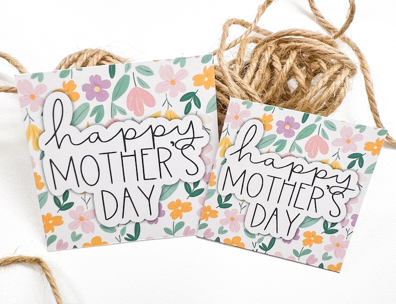 May include: Two white cards with a floral pattern and the text "happy mother's day" in black script.