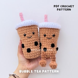 May include: A crochet pattern for making two brown bubble tea plush toys with white lids and pink straws. The toys have black eyes and a smiling face. The pattern is called "Bubble Tea Pattern" and is available as a PDF download.