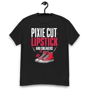 May include: Black t-shirt with the text "PIXIE CUT LIPSTICK AND SNEAKERS" in white and red. The design includes red lipstick tubes, red lips, and a pair of red high-top sneakers.