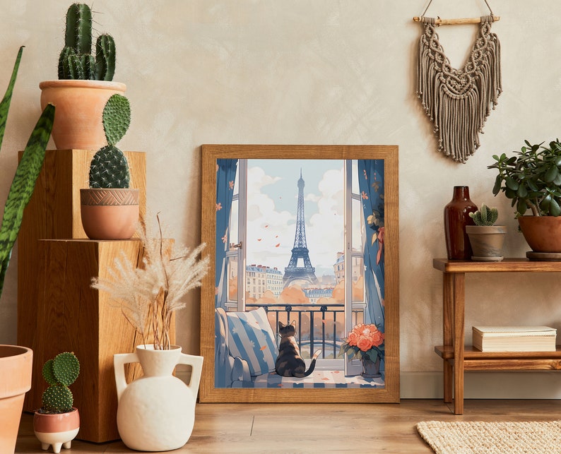May include: A framed print of a Parisian cityscape with a cat sitting on a windowsill. The print features a view of the Eiffel Tower and a balcony with flowers. The frame is brown wood and the print is on a white background.