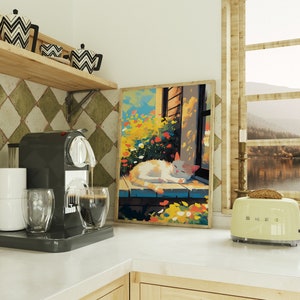 May include: A white cat with orange markings is sleeping on a windowsill in a colourful painting. The painting is framed and hanging on a wall in a kitchen. There is a coffee machine and a toaster on the counter.