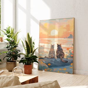 May include: A painting of two cats sitting on a rock overlooking a sunset ocean scene. The cats are facing the ocean and have their backs to the viewer. The sky is a vibrant orange and pink, and the water is a deep blue.