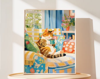 Puede incluir: Un gato atigrado con ojos verdes se relaja en un sillón de patrones coloridos. El gato sostiene una taza azul y parece estar disfrutando de una bebida caliente. El sillón está decorado con almohadas de varios patrones y colores, incluyendo rojo, amarillo, azul y verde.