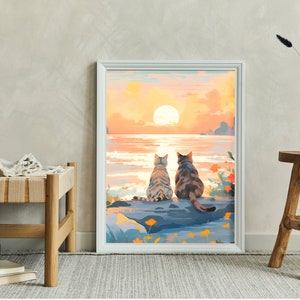 May include: A framed painting of two cats sitting on a rock by the ocean, watching the sunset. The sky is a vibrant orange and pink, and the water is a calm blue. The cats are facing away from the viewer, and their tails are curled around their bodies.