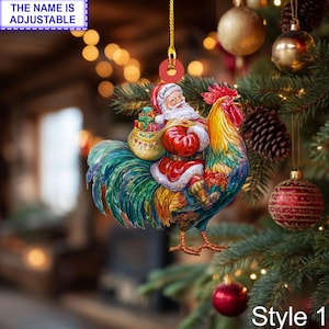 May include: A Christmas ornament featuring Santa Claus riding a colorful rooster. Santa wears a red suit and carries a sack of gifts. The ornament has a gold string for hanging and the text "THE NAME IS ADJUSTABLE" is visible.