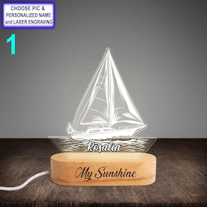 May include: A white sailboat with waves and the name "Rosalia" engraved on a wooden base. The base also has the text "My Sunshine" engraved on it.