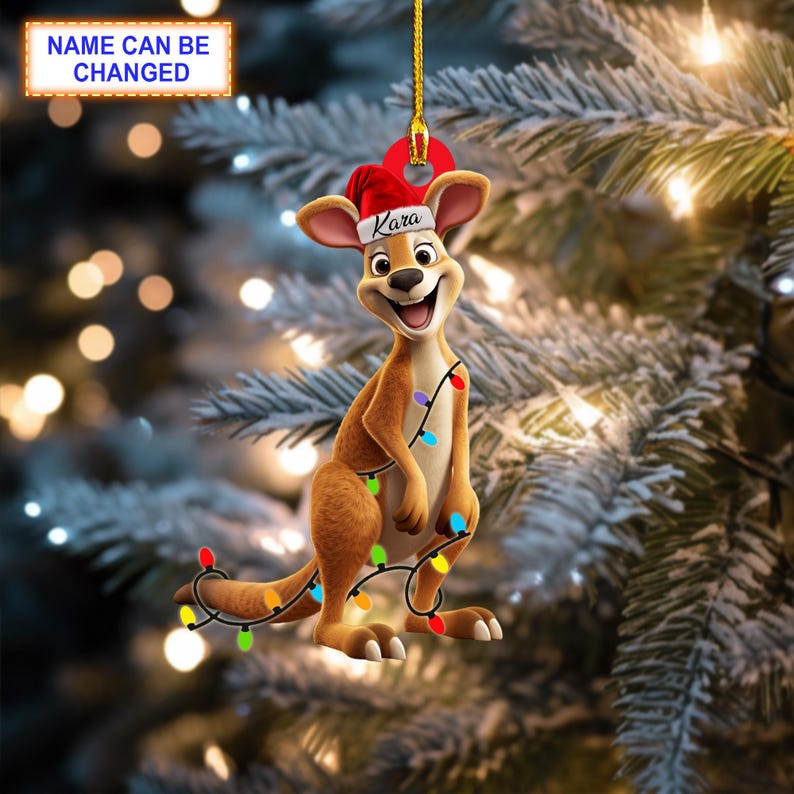Op de afbeelding: Een kerstversiering met een cartoon-kangoeroe die een kerstmanmuts draagt met de naam "Kara" erop. De kangoeroe houdt een string met gekleurde lampjes vast.