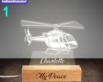 May include: A white helicopter silhouette night light on a wooden base with the name "Charlotte" and the phrase "My Peace" engraved on it.