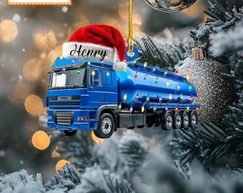 May include: A blue tanker truck Christmas ornament with a red Santa hat that says "Henry" on it. The truck is decorated with white Christmas lights.