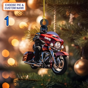 May include: A red and chrome motorcycle ornament with a rider wearing a black helmet and leather jacket. The ornament has the name "DAVID" printed on the side.