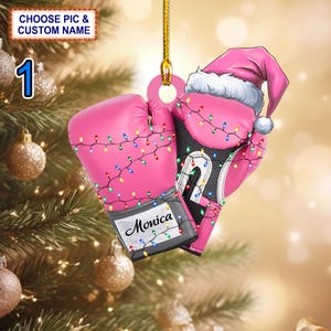 May include: Pink boxing gloves with a Santa hat on one glove, decorated with colorful Christmas lights and the name "Monica" on the glove.