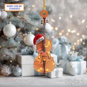 May include: A violin-shaped Christmas decoration with a Santa hat and fairy lights. The ornament has the text "Custom" on the hat and "Name Can Be Changed" on a banner. The background includes a Christmas tree and wrapped gifts.