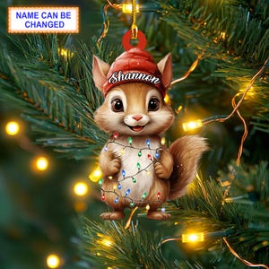May include: A cute cartoon squirrel wearing a red Santa hat with the name "Shannon" on it. The squirrel is holding a string of colorful Christmas lights.