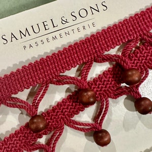 May include: Red and brown trim with wooden beads. Samuel & Sons Passementerie.